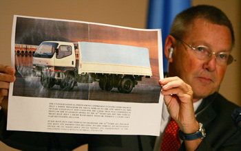 Detlev Mehlis, the German judge who was the UN commission's first chief investigator, holds up a photo in June 2005 of a white Mitsubishi truck, like the one that housed the 1,000 kg bomb that killed Hariri. (Jamal Saidi/Reuters)