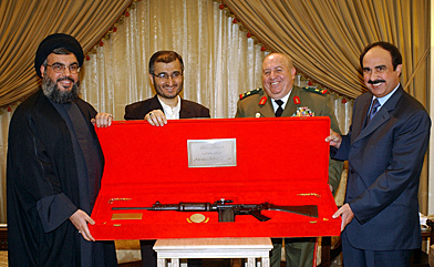 Hezbollah leader Sheikh Nasrallah (left) and his top aide, Hussein Khalil (second from left), present a gift rifle to the head of the Syrian intelligence service to Lebanon, Rustom Ghazali (far right) in April 2005, two months after the Hariri murder and only days before Syria would pull the last of its troops from Lebanon. Looking on is Gen. Fayed al-Haffar. According to UN investigators, Khalil and Col. Hassan exchanged numerous phone calls in 2004 and 2005. (Reuters photo)