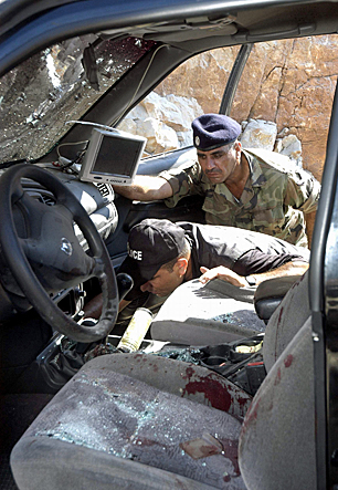 Lebanese officials inspect the aftermath of an attempt on the life of Lt.-Col. Samer Shedaheh, Eid's boss at the ISF. Shedaheh survived the car bomb attack, near Sidon, in September 2006 and was sent to Canada for treatment and resettlement. (Kamel Jabe/Reuters)