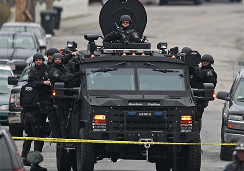 Police in tactical gear arrive on an armored police vehicle search for Dzhokhar Tsarnaev / AP
