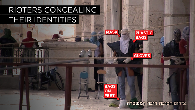 Palestinians are shown wearing plastic bags and gloves while rioting from within al-Aqsa mosque. (Photo: Israel Police)