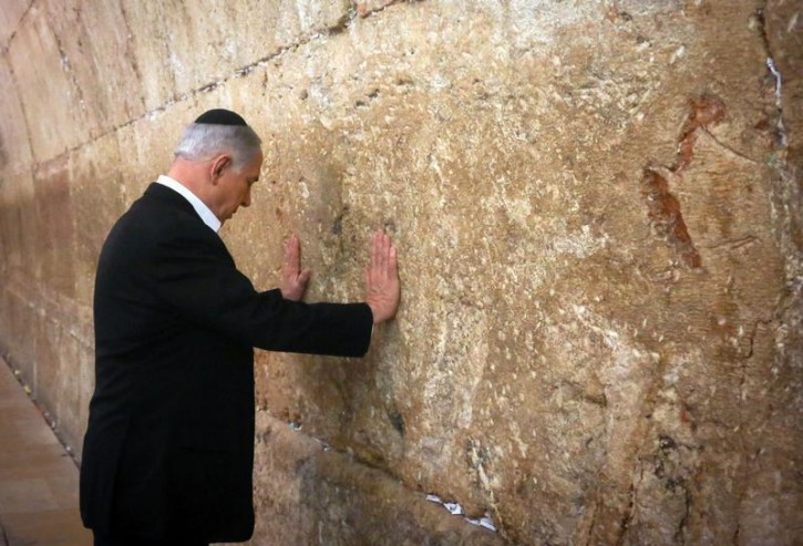 Israel's Prime Minister Benjamin Netanyahu touches the Western Wall, Judaism's holiest prayer site, during a visit in Jerusalem's Old City February 28, 2015. REUTERS/Marc Sellem/Pool