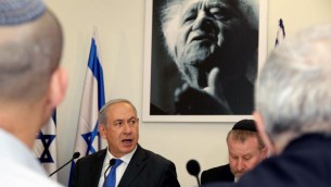 Prime Minister Benjamin Netanyahu sits under a portrait of the first Israeli prime minister David Ben-Gurion as he speaks during a special cabinet meeting at the Sde Boker academy to mark 40 years since Ben-Gurion's death. November 10, 2013. (Photo credit: Edi Israel/POOL/Flash90)