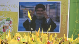 Hezbollah leader Sheikh Hassan Nasrallah delivers a speech shown on a screen during a rally commemorating "Liberation Day," which marks the withdrawal of the Israeli army from southern Lebanon in 2000, in the southern town of Nabatiyeh, Lebanon, Sunday, May 24, 2015.  (AP Photo/Mohammed Zaatari)