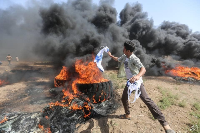 Burning the Israeli flag (Facebook page of the "supreme authority of the great return march," June 8, 2018).