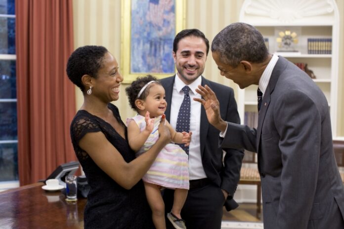 President Barack Obama greets Alya Dorelien Bitar, the one-year-old daughter of Maher Bitar, the outgoing National Security Council Director for Israeli and Palestinian Affairs, and his wife, Astrid Dorelien, during a family photo in the Oval Office, Sept. 21, 2015. (Official White House Photo by Pete Souza)