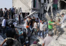 From Sderot to Tehran: Unmasking the architects of the ‘double war crime’ Iranians sift through the rubble of the Shajareh Tayyebeh girls’ school in Minab, Iran, destroyed by a missile strike on the first day of the joint U.S.-Israeli war on Feb. 28, 2026. Credit: Abbas Zakeri/Mehr News Agency/Creative Commons via Wikimedia Commons.