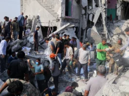 From Sderot to Tehran: Unmasking the architects of the ‘double war crime’ Iranians sift through the rubble of the Shajareh Tayyebeh girls’ school in Minab, Iran, destroyed by a missile strike on the first day of the joint U.S.-Israeli war on Feb. 28, 2026. Credit: Abbas Zakeri/Mehr News Agency/Creative Commons via Wikimedia Commons.