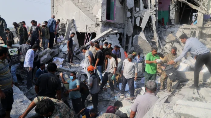 Iranians sift through the rubble of the Shajareh Tayyebeh girls’ school in Minab, Iran, destroyed by a missile strike on the first day of the joint U.S.-Israeli war on Feb. 28, 2026. Credit: Abbas Zakeri/Mehr News Agency/Creative Commons via Wikimedia Commons.